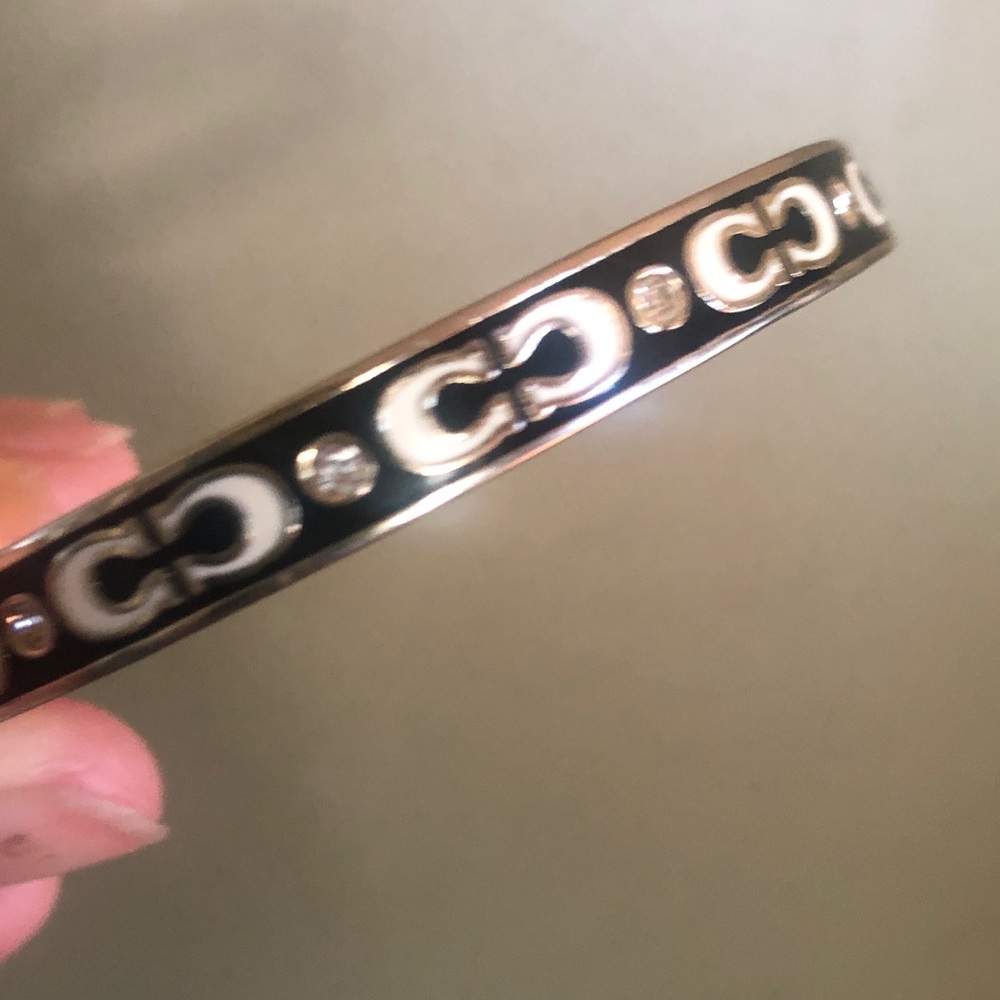 Coach hinged bracelet; enamel clear zirconium; opposing CC logo; ellipse